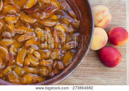 Fresh Bright Peaches And Nectarins Lay On The Stone Bricks, Close To The Copper Jar, Full Of Peach J