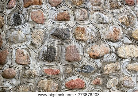 Wall Of Multi-colored Round Stone Fastened With Concrete
