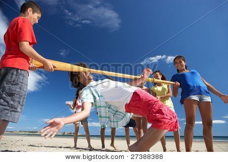 Adolescenti facendo limbo dance sulla spiaggia