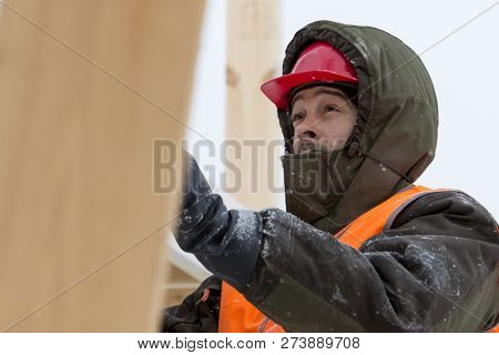 Worker Fitter In A Protective Helmet And Reflective Vest On The Working Meast