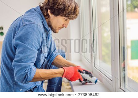 Man In A Blue Shirt Does Window Installation