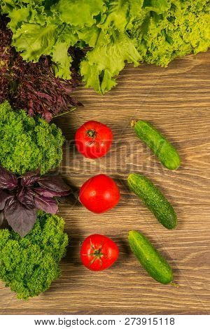 Composition With Fresh Vegetables. Tomatoes And Cucumbers On The Table