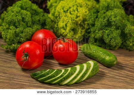 Tomatoes And Cucumbers On An Old Wooden Table. The Concept Of A Healthy Diet