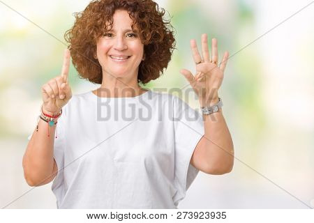 Beautiful middle ager senior woman wearing white t-shirt over isolated background showing and pointing up with fingers number six while smiling confident and happy.