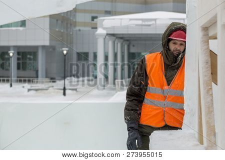 Worker Fitter In A Protective Helmet And Reflective Vest On The Working Meast