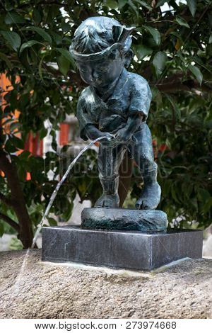 Fukuoka, Japan-October 19, 2018: Fountain sculpture of a little boy dressed in festival clothing taking a pee at the Kushida ninja shrine grounds