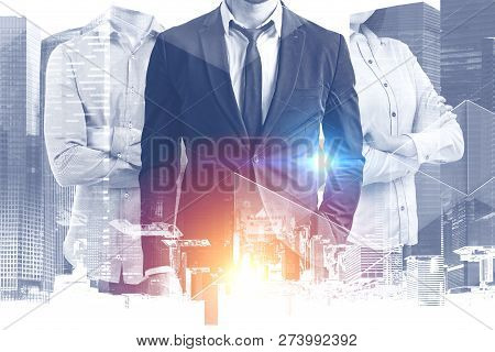 Two Unrecognizable Businessmen And Businesswoman With Crossed Arms Standing Over Modern Cityscape Ba