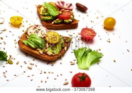 Toasts With Vegetables, Avocado, Tomatoes, A Set Of Seeds On A White Background. Healthy Food, Diet