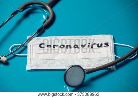 Mask With Word-coronavirus And Phonendoscope On Blue Background. Medine And Healthcare Concept