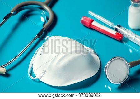 Different Medical Items- Mask, Test Tube, Phonendoscope And Ampulas On Blue Background. Medicine And