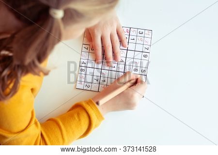 Teen Girl Solving Sudoku At School Or At Home. View From Above