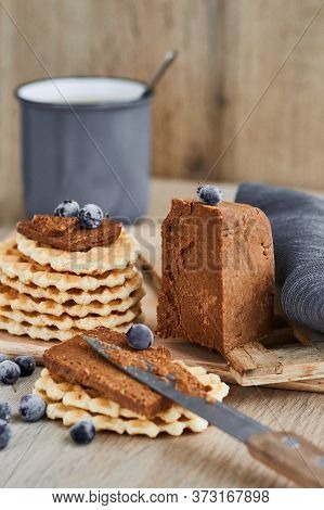 Viennese Waffles With Norwegian Brunost Cheese And Blueberries With A Cup Of Coffee In The Backgroun