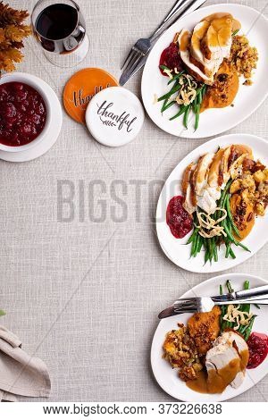 Festive Thankgiving Dinner Table With Plates Of Food, Turkey And All The Sides With Copy Space