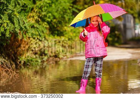 Adorable Toddler Girl With Colorful Umbrella Outdoors At Autumn Rainy Day