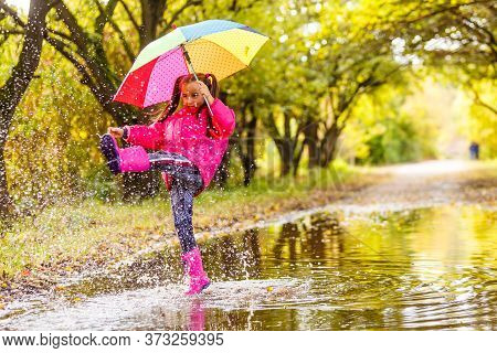 Adorable Toddler Girl With Colorful Umbrella Outdoors At Autumn Rainy Day