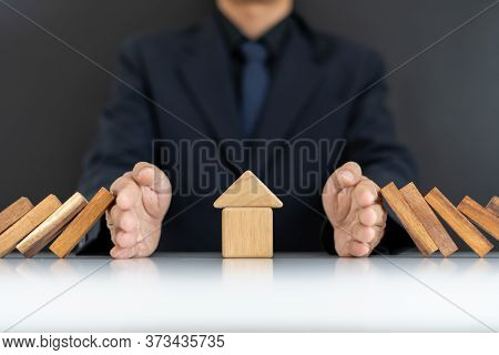The Concept Of Home Insurance.the Hands Of Businessmen Or Homeowners That Are Blocking Domino's Fall