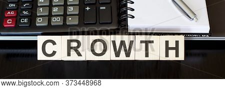 Crowth - Business Concept Text On Wood Block With Laptop, Calculator And Notebook
