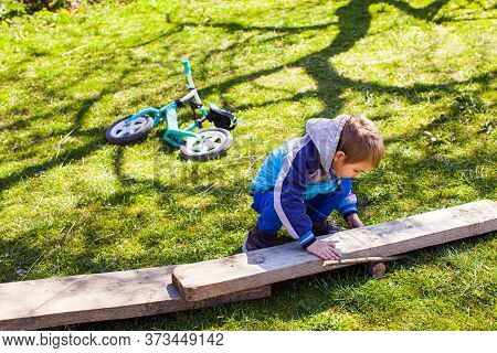 Little Boy Constructing A Wooden Road At The Backyard