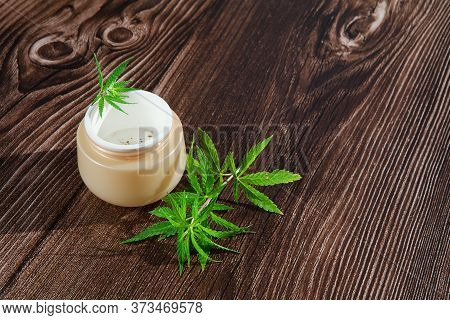 Hemp Twig And Cannabis Cream With Marijuana Leaf In Jar On Wooden Background. Concept Of Herbal Alte