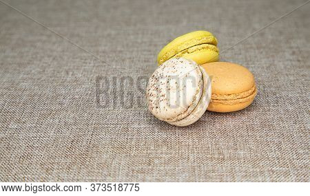 Closeup Image Of Three Magaroons On Light Brown Cloth Background.