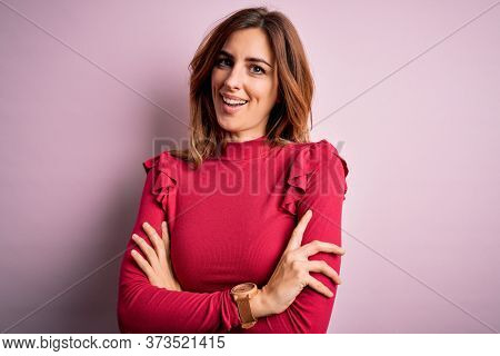 Young beautiful brunette woman wearing casual sweater stnding over pink background happy face smiling with crossed arms looking at the camera. Positive person.