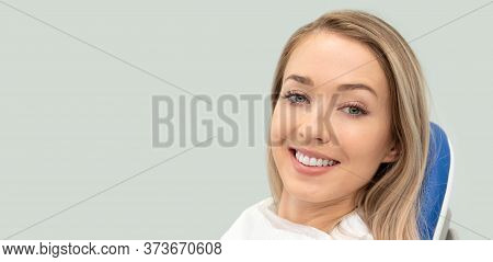 Young Smiling Woman Sitting On Chair At Dentist Office. Dental Care, Healthy Teeth. Wide Image With 