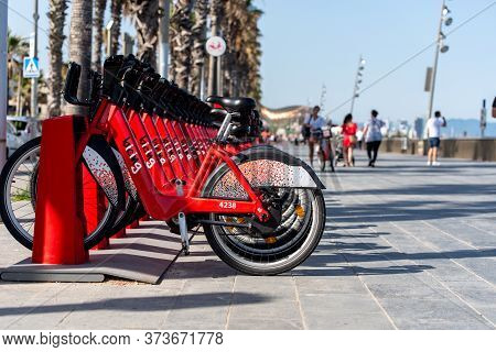 Barcelona, Spain - June 26, 2020: Bright Red Bicycles Available For Rent Parked In A Row At La Barce