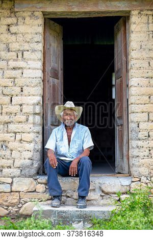 El Chorrito, Tamaulipas, Mexico, July 2, 2019: Mexican Senior, At His Adobe Home, Waits By His Door