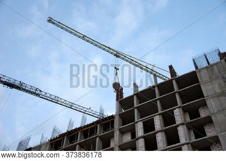 Preparing To Pour A Bucket Of Concrete Into Formwork.tower Crane Lifting Cement Bucket During Constr