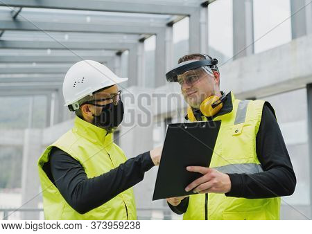Portrait Of Workers With Face Mask At The Airport, Discussing Issues.