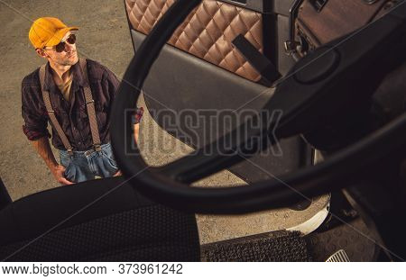 Middle Age Male Trucker Standing Outside Of Vehicle Cab And Looking Around.