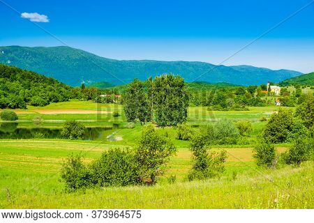 Beautiful Green Landscape In Lika Region Croatia, On Svica Lake And Mountains In Background