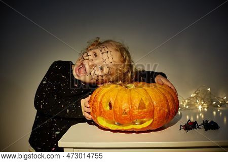 Happy Halloween. Cute Little Funny Baby With A Big Jack Olantern Pumpkin. Copy Space.
