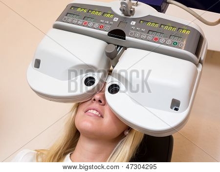 Cliente di un oculista o ottico guardando attraverso forottero