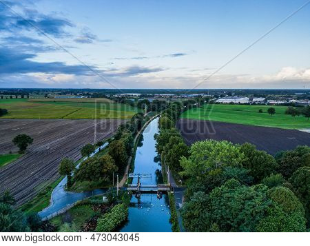 Aerial View Of A Colorful Dramatic Sunrise Sky Over A Canal With A Draw Bridge In Belgium. Canals Wi