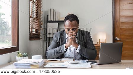Stressed Business Man Sitting At Office Workplace. Tired And Overworked Black Man. Young African Ame