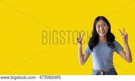 Young Asian woman making two thumbs up gesture showing joy and fun, Symbol of good friendship, Popul