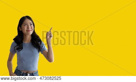 Asian woman pointing finger inviting click here, It is recommended to follow this direction or click