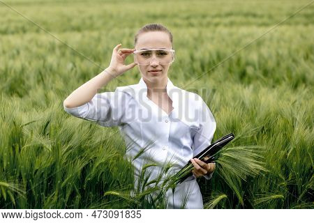 Ecologist In A White Coat And Glasses Examining Plants