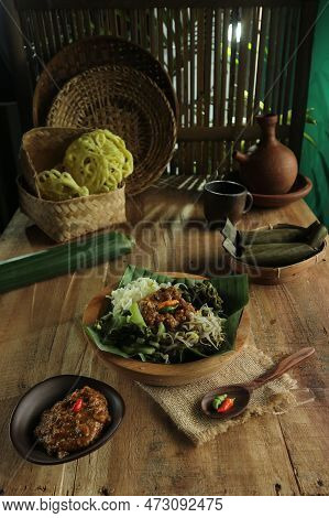 Indonesian Salad With Spicy Peanut Sauce On A Rustic Table