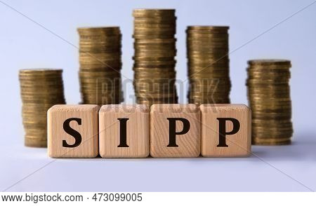 Sipp (self Invested Personal Pension) - Acronym On Wooden Cubes On Coins On A Gray Background. Busin