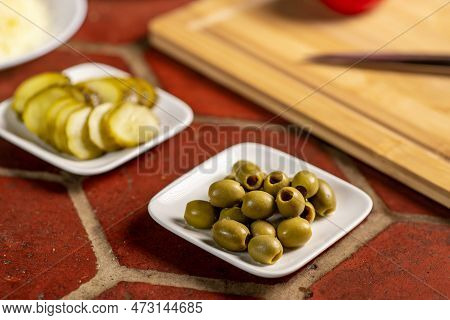 Olives On A Plate Close-up. Various Ingredients For Making Pizza.