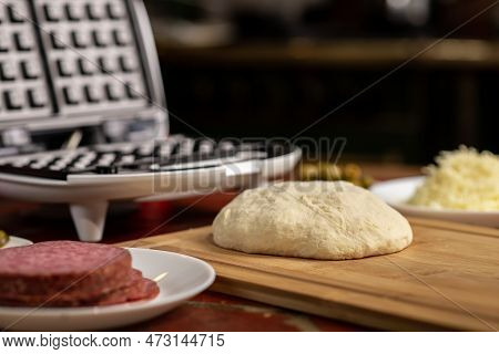 Cooking Pizza Waffle, Piffle. Waffle Iron And Yeast Dough For Pizza And Various Ingredients - Salami