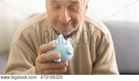 Senior Man Holding Piggy Bank. Financial Security Planning Concept. Economy And Saving.