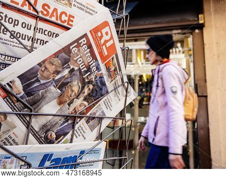 Paris, France - Mar 20, 2023: Adult Walking Near Press Kiosk With Multiple French Press Newspaper Fe