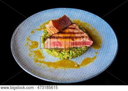 Beefsteak Medium Rare With Blood Served With Peas Isolated On Black Background Side View