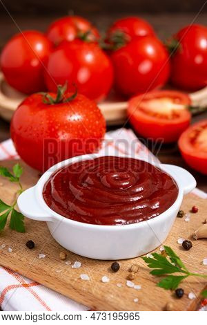 Cutting Board Witch Bowl Of Ketchup Or Tomato Sauce, Spices And Fresh Tomatoes On Wooden Table. Sele