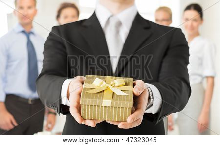 close up of man hands holding gift box in office
