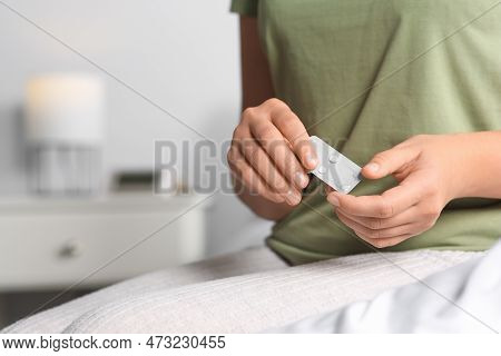 Woman Holding Emergency Contraception Pills In Bedroom, Focus On Hands. Space For Text