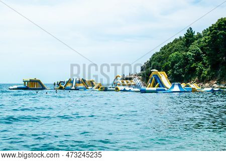 People On Inflatable Entertainment Water Attractions And Slides On Sea. Morgen Beach, Montenegro.